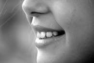 A monochrome close-up of a smiling face showcasing teeth and lips.